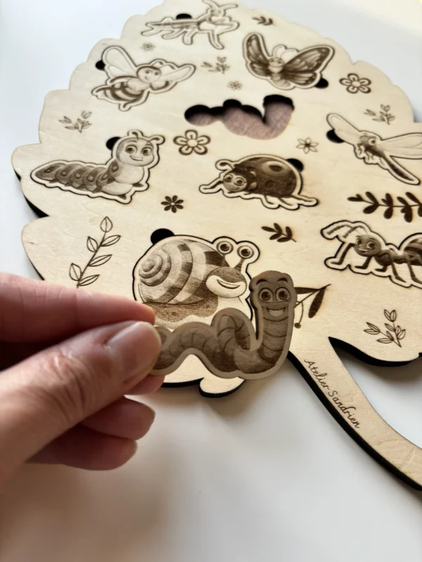 Détail Puzzle en bois - Les insectes une pièce tenue en main