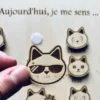 Tableau éducatif en bois - Mes émotions "chat" un jeton tenu en main