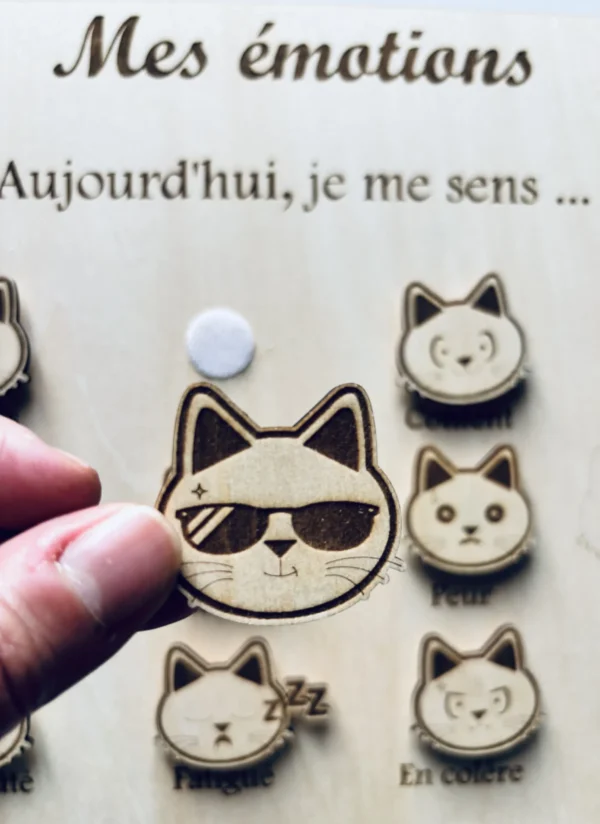 Tableau éducatif en bois - Mes émotions "chat" un jeton tenu en main
