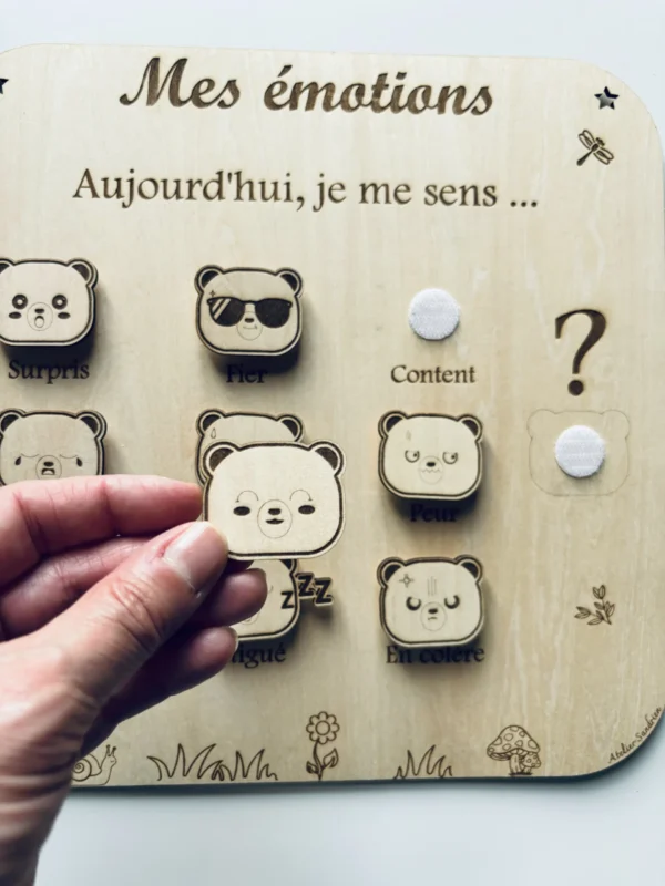 Tableau éducatif en bois - Mes émotions "ours" un jeton tenu en main