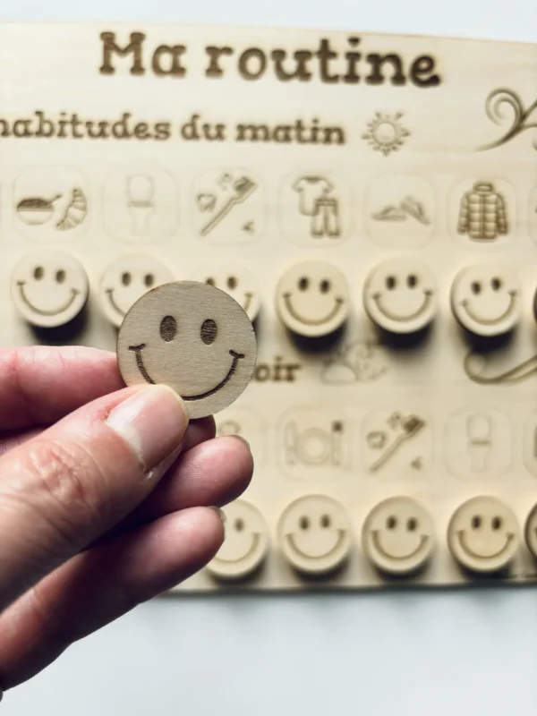 Zoom tableau de routine en bois avec un jeton tenu en main