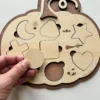 Puzzle en bois en forme de citrouille Halloween - le rond tenu en main