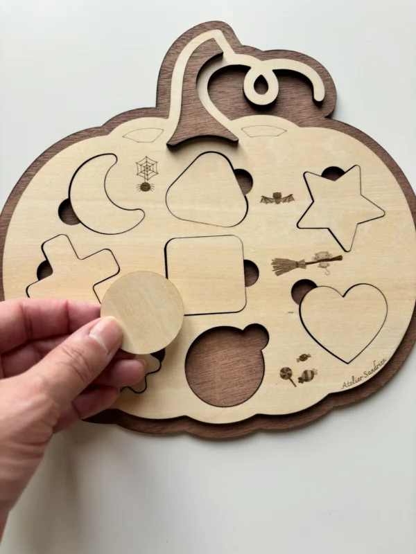Puzzle en bois en forme de citrouille Halloween - le rond tenu en main
