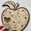 Puzzle en bois - Pomme - pièces en forme géométriques avec la pièce coeur tenue en main