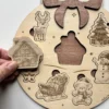 Puzzle en bois en forme de boule de noël - avec la pièce chalet tenue en main
