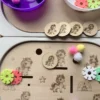 Enfant jouant avec un insert sensoriel licornes en bois et accessoires pour activité de tri et motricité fine