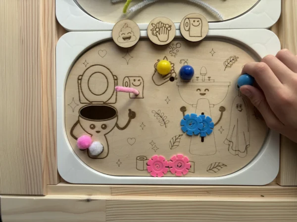 Insert sensoriel en bois autonomie aux toilettes accessoires colorés dans bols main d'enfant qui joue