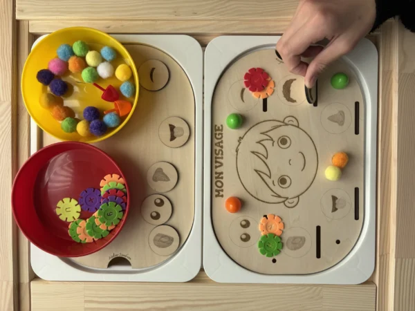 Insert sensoriel en bois le visage accessoires colorés dans bols et accessoires posés et main d'enfant
