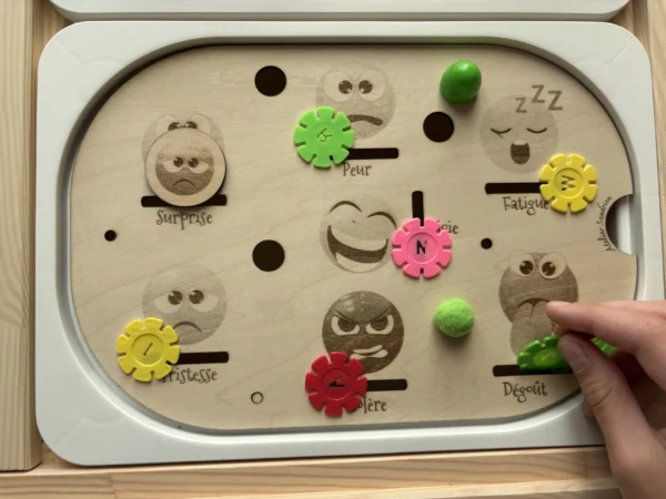 Insert sensoriel en bois les émotions accessoires colorés dans bols main d'enfant qui joue