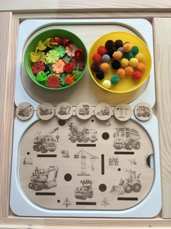 Insert sensoriel en bois avec engins de chantier gravés, jetons ronds et accessoires colorés à manipuler déposés dans 2 bols