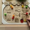 Insert sensoriel en bois avec véhicules gravés (version réaliste), jetons ronds et accessoires colorés à manipuler avec main d'enfant qui joue