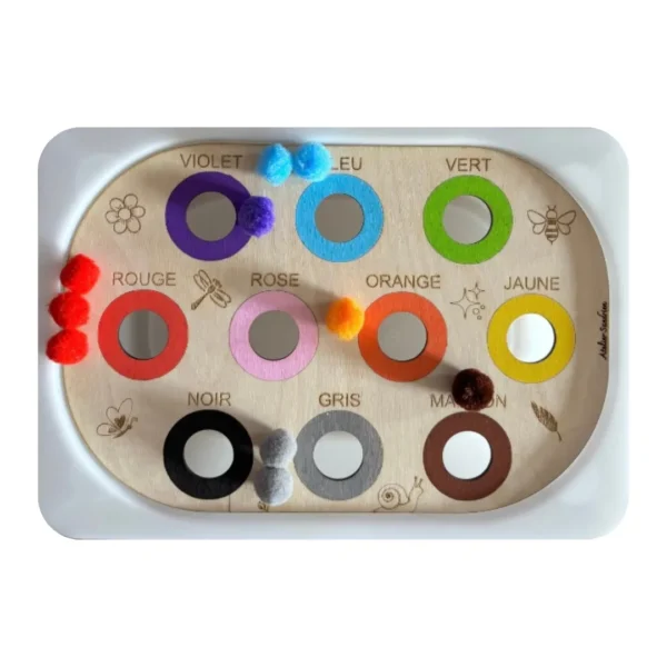 Insert sensoriel en bois - Atelier des couleurs pompons de couleurs posés dessus