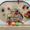 Main d’enfant décorant un gâteau d’anniversaire en bois avec accessoires sensoriels