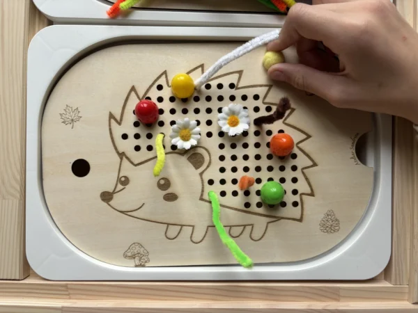 insert sensoriel en bois hérisson avec main enfant qui insère un pompon motricité fine