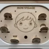 Insert sensoriel en bois le visage et ses jetons associés insérés