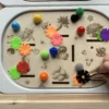 légumes gravés sur un insert sensoriel en bois avec pompons et fleurs