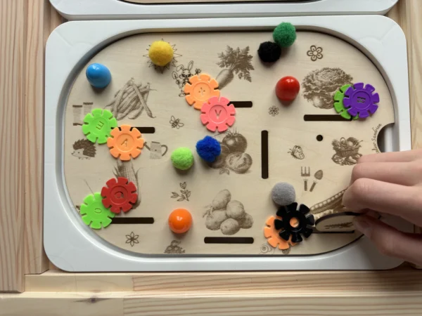 légumes gravés sur un insert sensoriel en bois avec pompons et fleurs