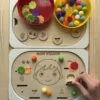 Insert sensoriel en bois le visage accessoires colorés dans bols et accessoires posés et main d'enfant