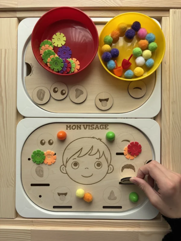 Insert sensoriel en bois le visage accessoires colorés dans bols et accessoires posés et main d'enfant