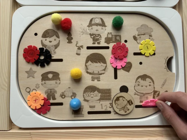 Main d’enfant utilisant un insert sensoriel en bois métiers du quotidien avec jetons pour activité de langage et motricité fine