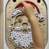 Insert sensoriel en bois père noël rempli de pompons rouges et blancs - avec main d'enfant
