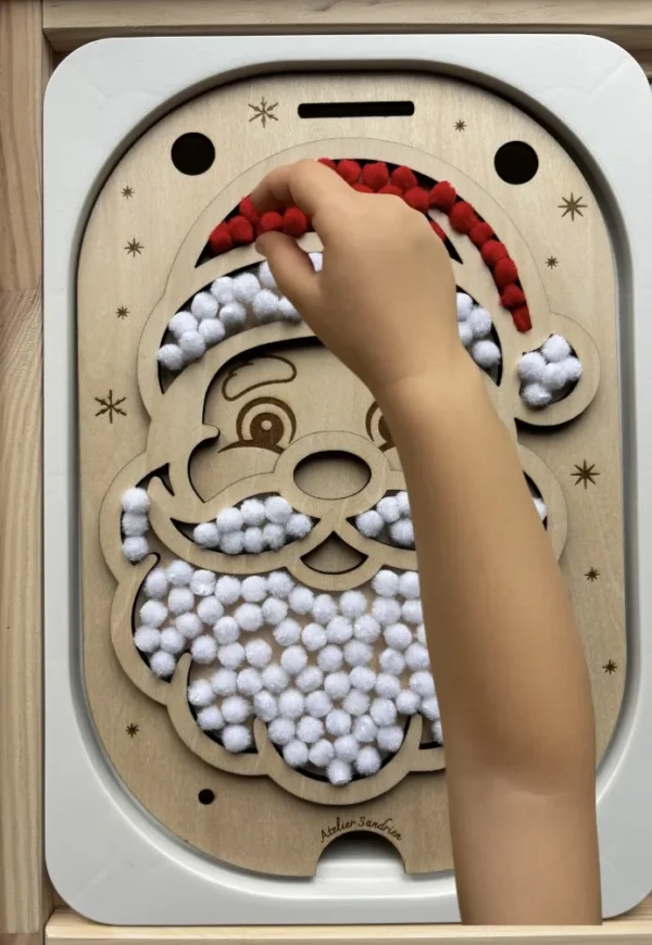 Insert sensoriel en bois père noël rempli de pompons rouges et blancs - avec main d'enfant