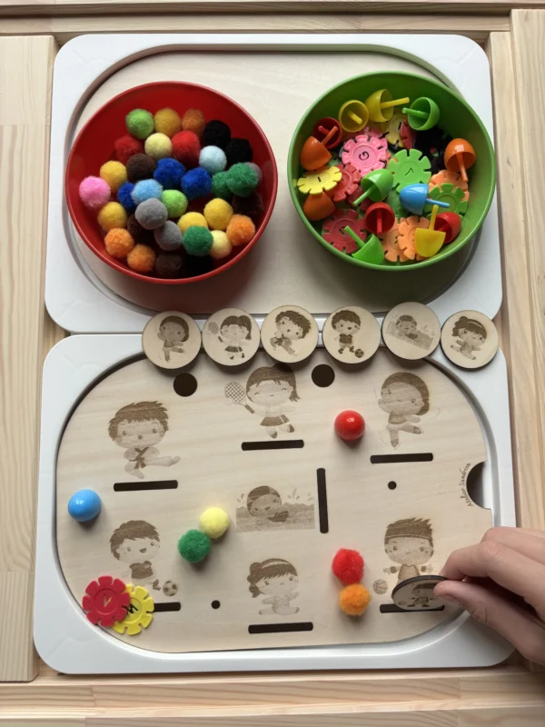 Main d’enfant utilisant un insert sensoriel sport en bois avec jetons et pompons