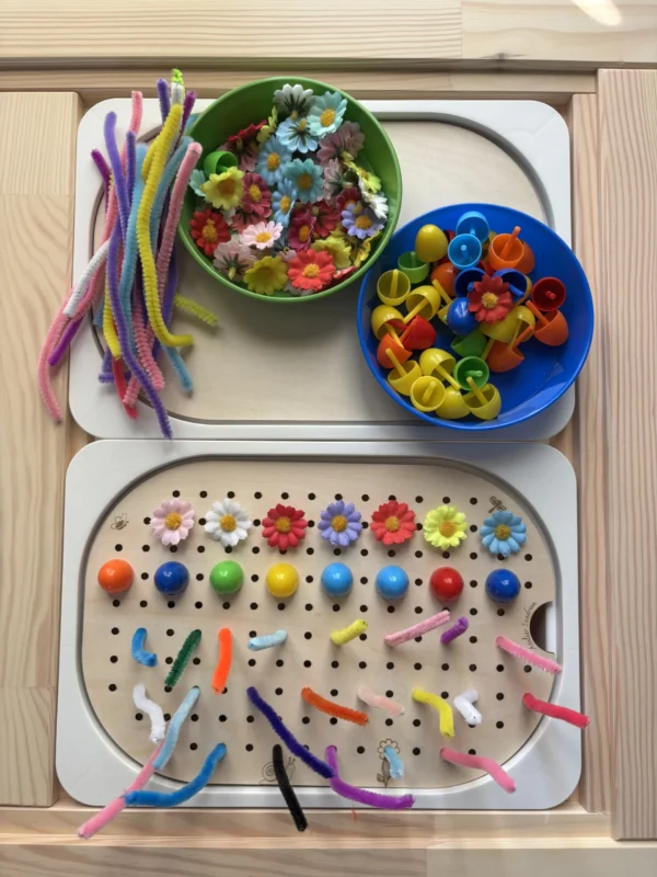 Insert sensoriel en bois avec trous picots plaque entière avec différents accessoires posés et dans deux bols