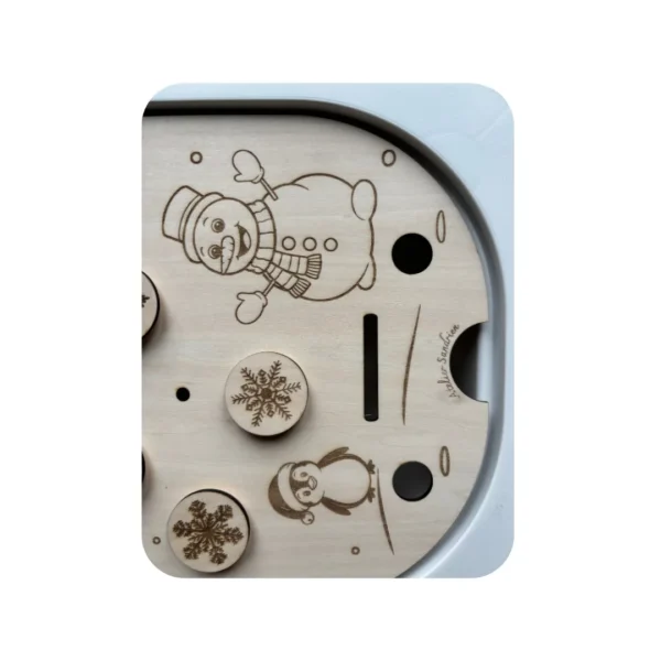 Détail des flocons de neige amovibles gravés sur insert sensoriel en bois thème hiver, motricité fine enfant