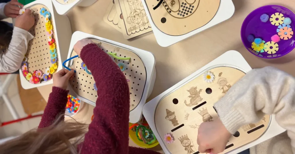 Atelier collectif avec des enfants utilisant des inserts sensoriels en bois, manipulation et observation en situation réelle.