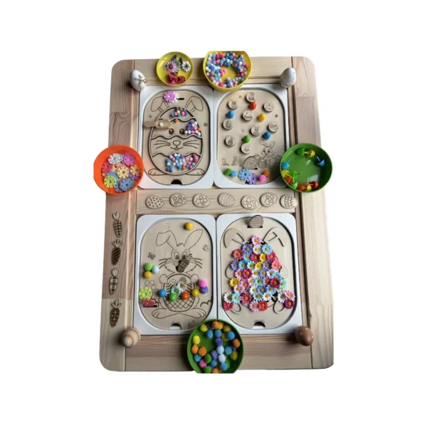 Plateau d’activités sensoriel en bois thème Pâques avec quatre inserts verticaux, bols d’accessoires colorés et éléments de tri pour développer la motricité fine des enfants.