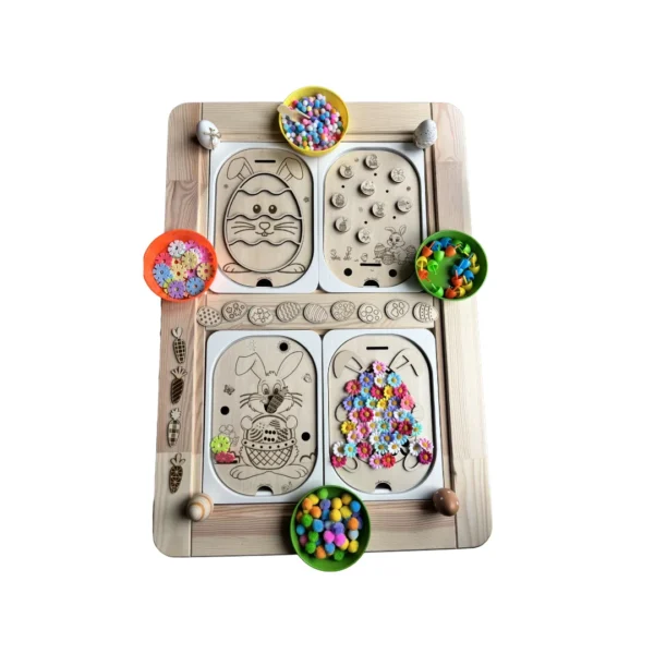 Plateau sensoriel en bois avec quatre inserts thème Pâques, bols d’accessoires colorés (pompons, perles, fleurs) pour activités de tri, motricité fine et créativité chez les jeunes enfants.