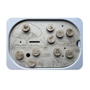 Insert sensoriel en bois sur le thème de la mare avec canards et jetons scratch amovibles pour activité de motricité fine, observation et langage enfant.
