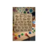 Tableau abécédaire en bois utilisé lors d’une activité éducative, avec lettres colorées non incluses