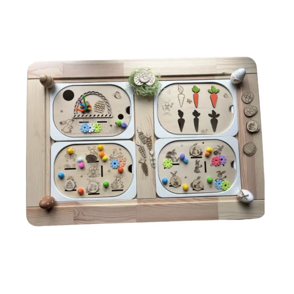 Ensemble de quatre inserts sensoriels en bois thème Pâques présentés dans un plateau, avec accessoires colorés pour activités de tri et motricité fine.