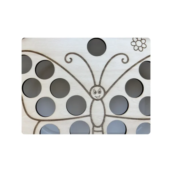 Détail des trous de 2,5 cm sur les ailes du papillon en bois – insert sensoriel pour motricité fine