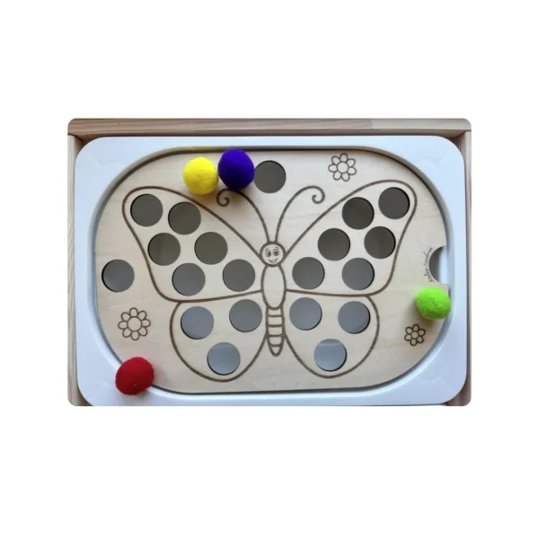 Pompons colorés posés sur le papillon en bois avec trous de 2,5 cm – insert sensoriel motricité fine