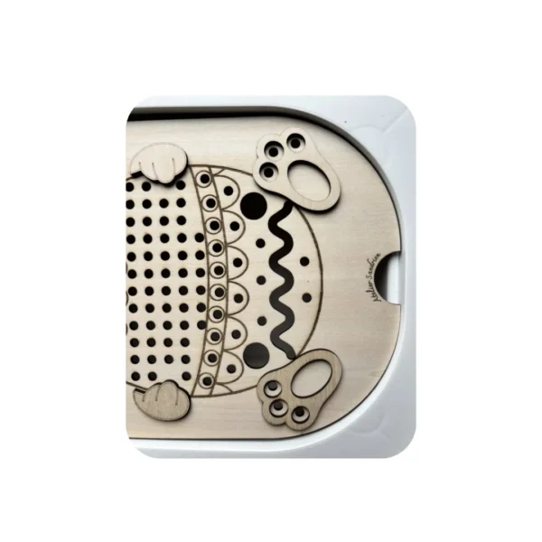 Zoom sur un insert sensoriel en bois thème Pâques montrant les zones perforées, gravures décoratives et emplacements d’activités pour développer la motricité fine chez l’enfant.