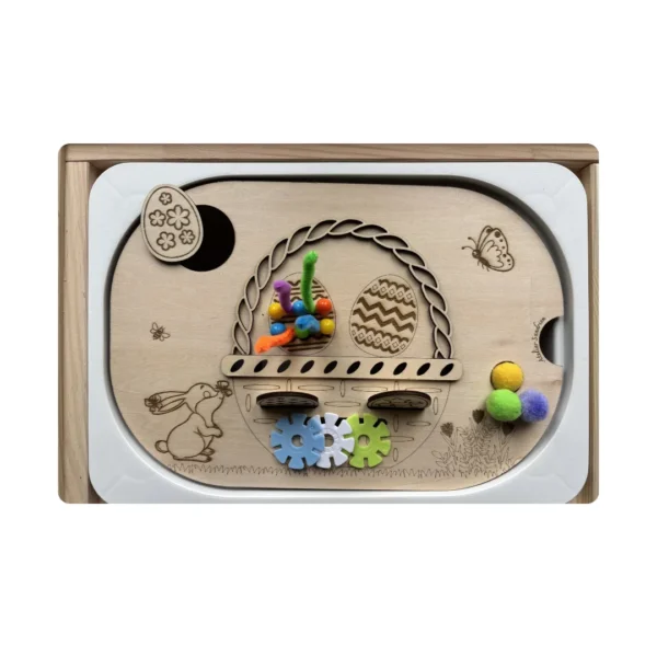 Insert sensoriel en bois thème panier de Pâques avec accessoires colorés, permettant aux enfants de manipuler, trier et développer leur motricité fine à travers le jeu.
