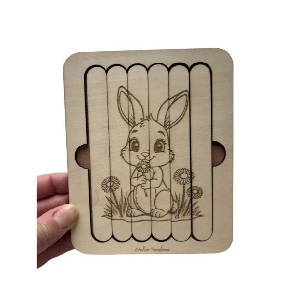 Puzzle bâtonnet lapin en bois tenu en main, montrant un jeu éducatif pour enfant favorisant la motricité fine et l’autonomie.