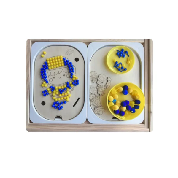 Insert sensoriel en bois -Cosmonaute à trous décoré avec pompons et picots bleus et jaunes