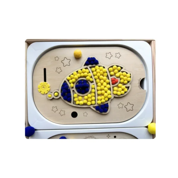 Insert sensoriel en bois -Cosmonaute à trous remInsert sensoriel en bois - Fusée remplie de pompons jaunes et bleus