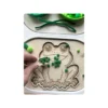 Insert sensoriel en bois - la grenouille à remplir avec main et pompons verts