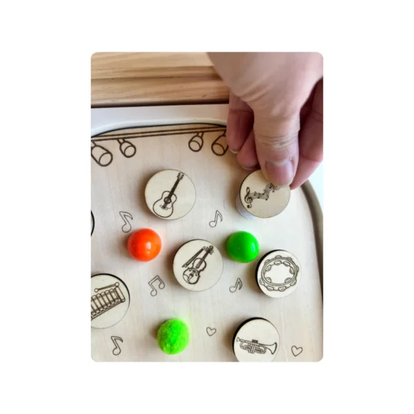 Insert sensoriel en bois - la musique jeton scratch tenu en main