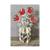Bouquet de 4 roses rouges en bois sur vase décoratif ajouré, vue de face