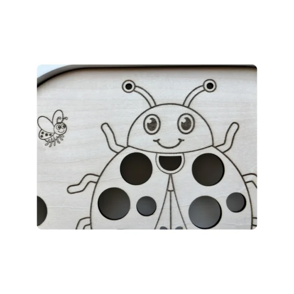 Détail coccinelle gravée sur insert sensoriel en bois pour activité de comptage et motricité fine enfant