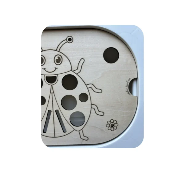 Détail coccinelle gravée sur insert sensoriel en bois pour activité de comptage et motricité fine enfant
