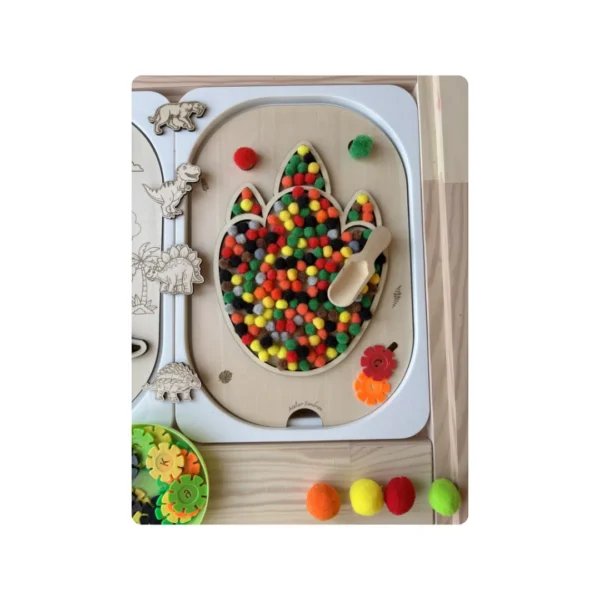 Insert sensoriel en bois empreinte de dinosaure rempli de pompons colorés