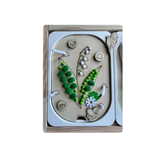 insert sensoriel en bois - brin de muguet avec accessoires blancs et verts posés