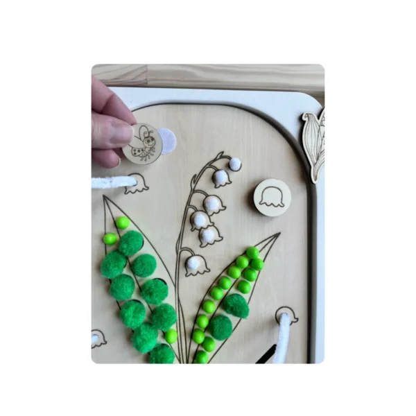 insert sensoriel en bois - brin de muguet avec jeton tenu en main et ses accessoires